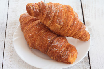 fresh croissants on white plate