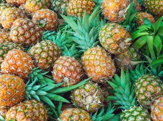 Several pineapples stacked in a fruit market
