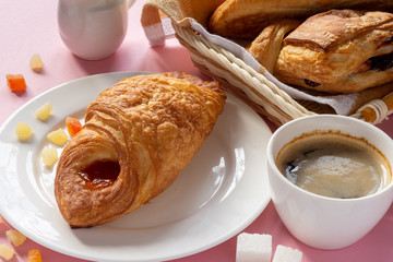 A variety of puff pastry buns with cherries, kiwi, apricot. Rolls, croissants with various fillings. A Cup of coffee with milk, Breakfast. Still-life.