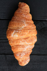 fresh croissant on black wood