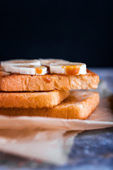 Two delicious toasts with salted caramel and bananas on the table.
