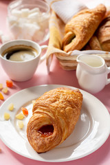 A variety of puff pastry buns with cherries, kiwi, apricot. Rolls, croissants with various fillings. A Cup of coffee with milk, Breakfast. Still-life.