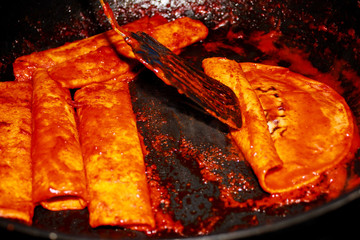 Enchiladas, platillo típico mexicano. Hecho con chiles guajillos y tortillas. Acompañado de cebolla, crema, queso, zanahorias, ppapas y lechuga
