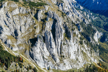 A man with a hiking backpack standing at the mountain ledge in Hochschwab region in Austria. There...