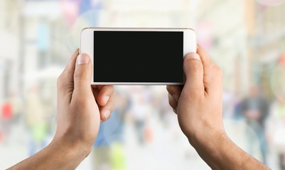 Hand holding smartphone with a blank screen