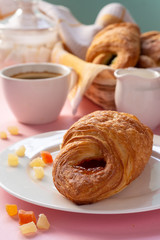 A variety of puff pastry buns with cherries, kiwi, apricot. Rolls, croissants with various fillings. A Cup of coffee with milk, Breakfast. Still-life.