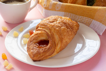 A variety of puff pastry buns with cherries, kiwi, apricot. Rolls, croissants with various fillings. A Cup of coffee with milk, Breakfast. Still-life.