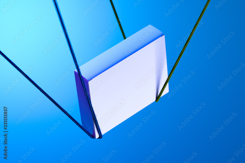 Poster white cardboard blank box tied with ropes on light blue background and illuminated by lights. 3d ren