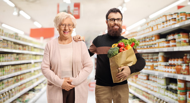 Bearded man helping a senior woman with shopping