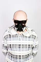 COVID-19 coronavirus and healthcare concept. Respiratory protection. Portrait of young man in black with respirator on his face over gray background