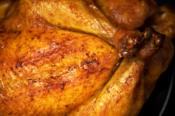 Whole roasted chicken in baking dish. Top view. Copy space. Macro shoot.