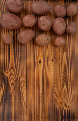Fresh raw organic red potatoes on old vintage background. Free space for text, top view