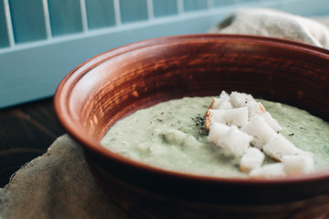 Green cream vegetable soup broccoli, peas, zucchini, spinach with croutons. Delicious vegetarian healthy food.