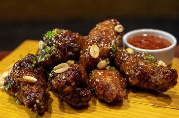 Porção de frango ao molho com decoração de amendoim e molho agridoce,  Kaarague com molho sweet chilli