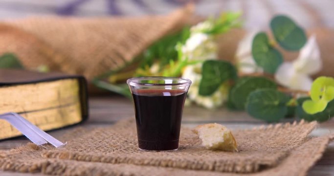 Taking communion concept - the wine and the bread symbols of Jesus Christ blood and body with Holy Bible. Easter Passover and Lord Supper concept. Dolly shot 4k