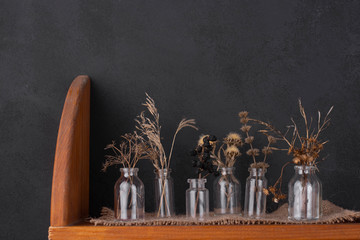 Bouquets of dry grass in glass bottles.
