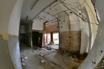 Wnętrze opuszczonego i zniszczonego budynku w słoneczny dzień. Gruzy i ruiny.