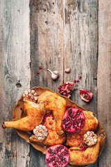 Traditional Thanksgiving day celebration party. Roasted chicken with pomegranate and garlic on wooden background. Friends or family dinner. Festive Christmas table. Top view