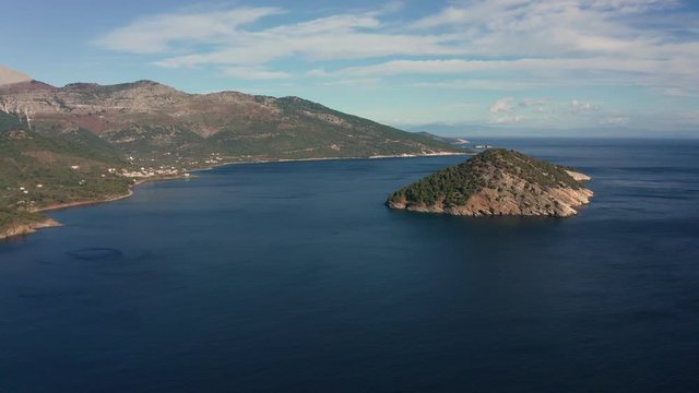 Drone flight around the mountain slopes and rocky coastline of Thasos island and the little island Nisida Kinira, Greece