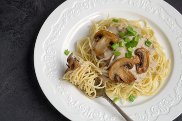 Spaghetti with mushrooms in cream sauce. on dark background