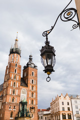 Fototapeta na wymiar St. Mary's basilica in main square of Krakow. A lantern hanging in the foreground. Poland's historic center, a city with ancient architecture. Cracow, Poland.