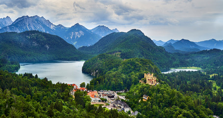 Fototapeta na wymiar Hoehenschwangau castle with Alpsee left and Schwansee right and Alps in the background.