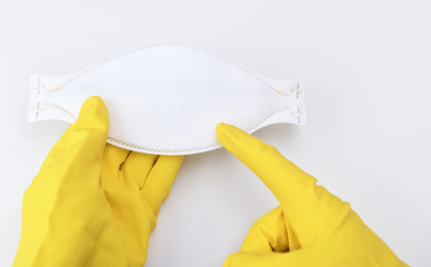 Means of protection against the virus, coronavirus. The medical mask lies in the hands in yellow...