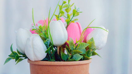 Bouquet of artificial flowers on a soft light blurred background_