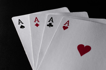 Four aces of playing cards on black background