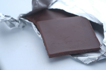 Pieces of dark chocolate isolated on white background, close up