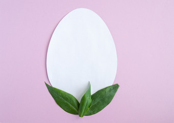 Easter creative composition.  Flat lay with shape of easter egg, frame  of flowers on pink  background. Minimal spring concept. Copy space