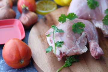 Raw chicken meat on wooden board, closeup.