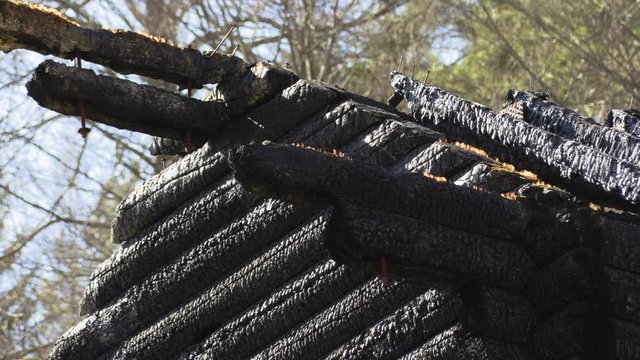burnt wooden log house, charred wood