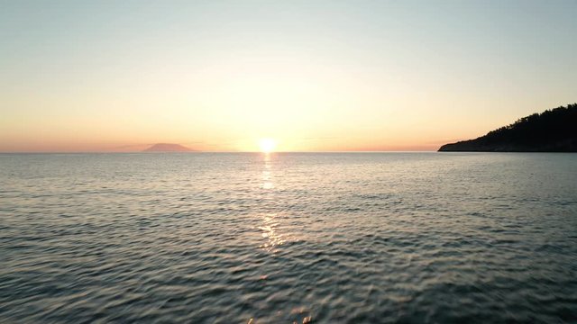 Drone flight with a wavy sea and beautiful sunrise - the Aegean Sea, Greece