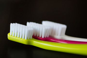 Bright toothbrushes close-up on a black background.