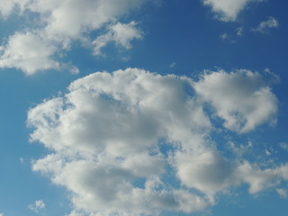Graying clouds on bright blue sky