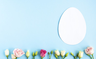 Easter creative composition.  Flat lay with shape of easter egg, frame  of flowers on pink  background. Minimal spring concept. Copy space