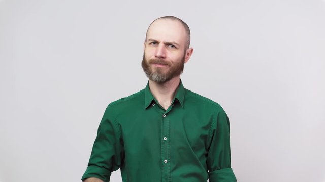 Man showing refusal gesture no, shaking his head and finger. Serious bearded man is gesturing negatively with his finger raised isolated over white background.