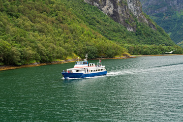Fototapeta na wymiar Passenger vessel sailing in Sognefjord, Norway, mountain fjord sea landscape view.