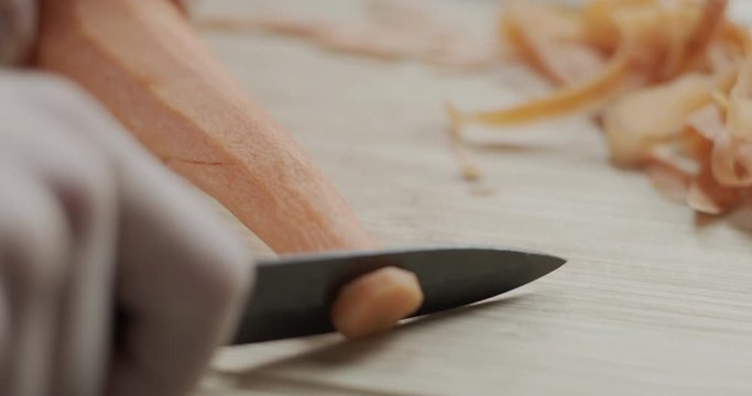 Cutting a carrot on a chopping board.
