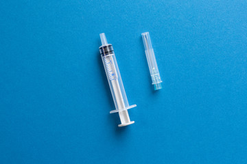 Syringe and needle on a blue background.