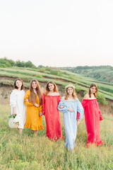 Obraz premium Happy relaxing friends on picnic in park, young beautiful girls having fun while spending time together in the summer garden. Women outdoor friendship concept. 