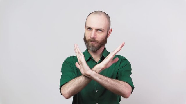 Man showing refusal gesture no. Serious bearded man is gesturing negatively isolated over white background.