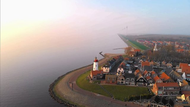 Lighthouse of urk on the rocky beach at the lake Ijsselmeer by the former island Urk Flevoland Netherlands, Bird eye view drone view of the old dutch village Urk
