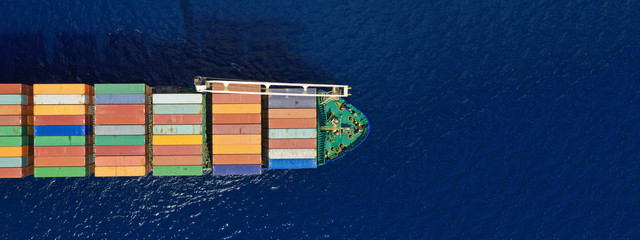 Aerial drone top down photo of fully loaded large truck size container tanker ship cruising the...