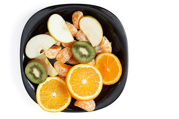 various sliced fruits on a white background in a black plate