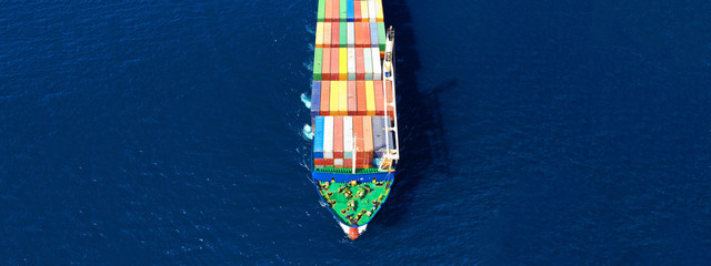 Aerial drone top down photo of fully loaded large truck size container tanker ship cruising the Mediterranean deep blue sea