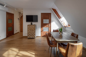 Modern contemporary interior of living room with furniture and tv. Sloping ceiling. Private house.