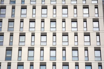 A view at a straight facade of a modern building with a dark grey facade. Dark grey metallic panel facad. Modern architectural details. 