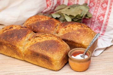 freshly baked bread is on a wooden table. salt